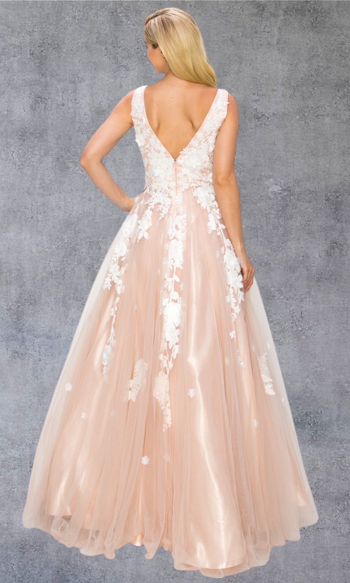 A woman poses with her back to the camera against a textured gray backdrop, showcasing the Cinderella Couture 8040J—a sleeveless, floor-length blush tulle formal dress adorned with elegant white 3D floral lace appliques, embodying true Cinderella Couture style.